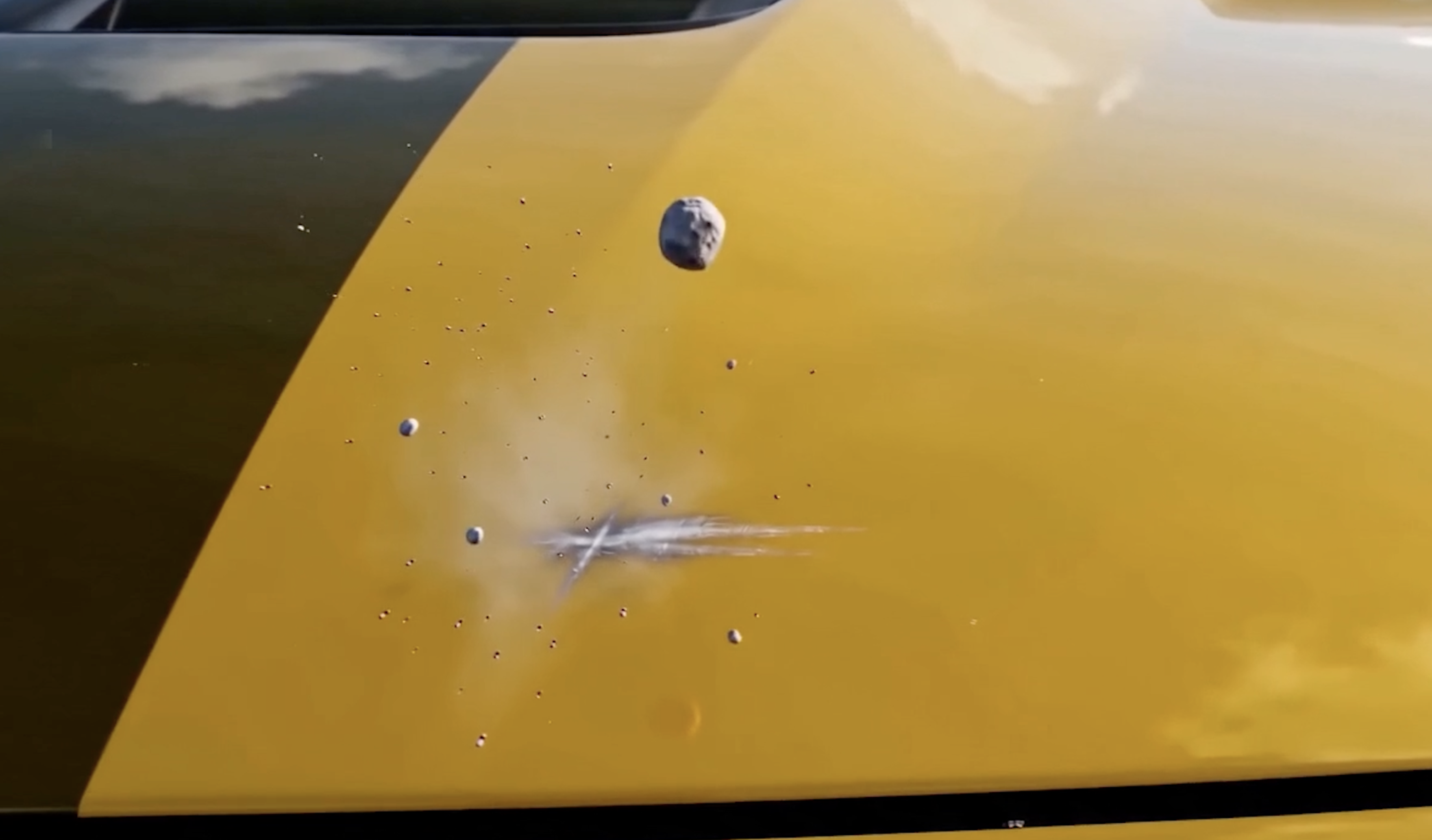 A stone striking the door of a yellow Mustang, absorbed by Forever Young PPF